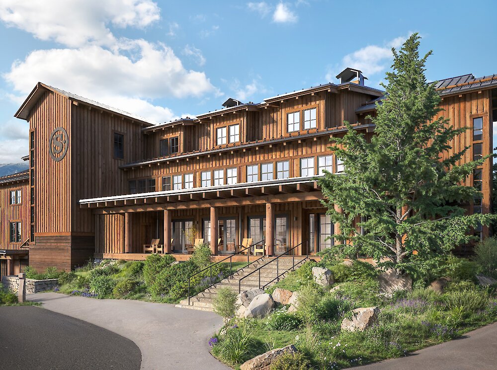 The front entrance of the Inn with blue sky and green landscaping.