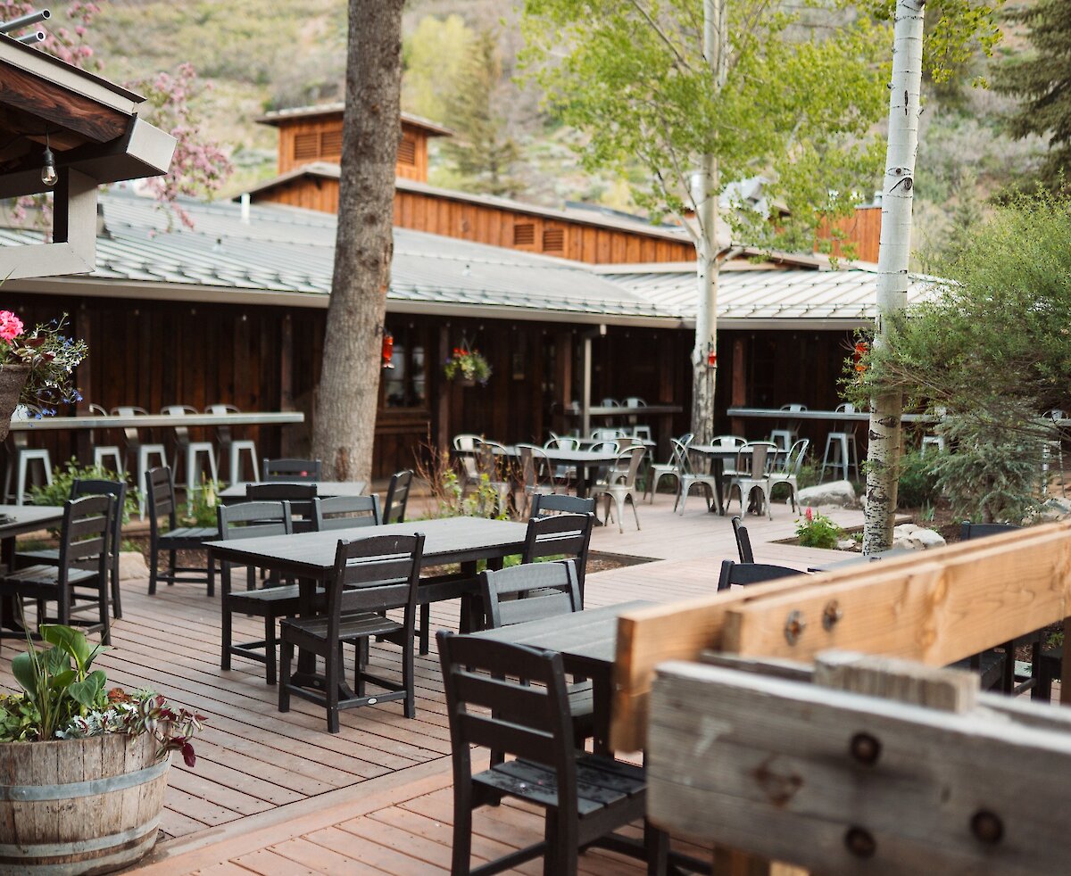 The Deli patio with tables, chairs, and blooming flours.