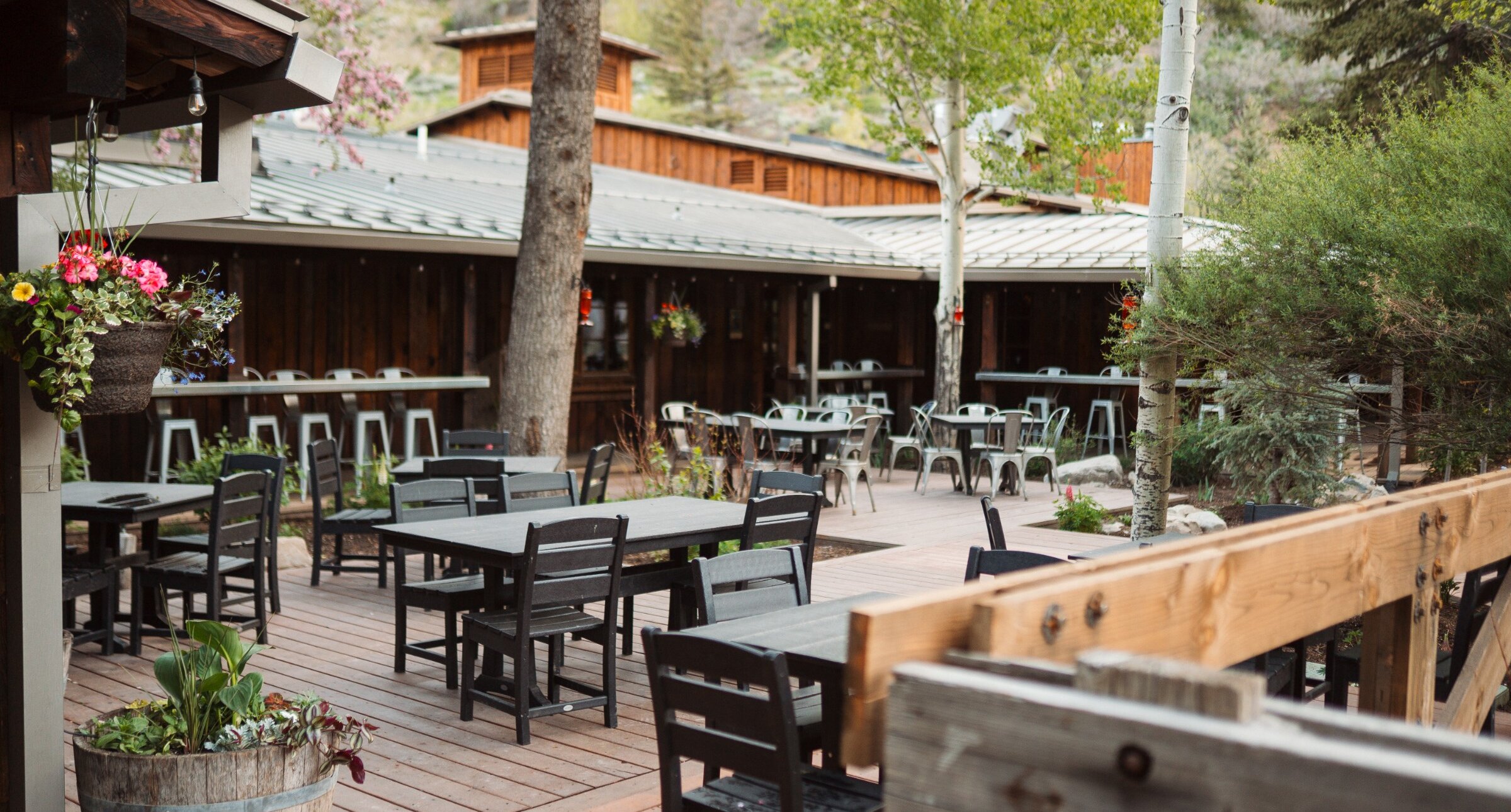 The Deli patio with tables, chairs, and blooming flours.