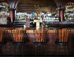 The old fashioned Owl Bar with high backed stools and fully stocked shelves.