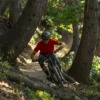 A mountain biker on the corner of a trail in the middle of the mountains.