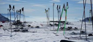 Pairs of skis and poles perched at the top of the mountain.