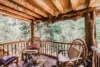 Delightful wood-covered patio with adorable rocking chairs and a fresh nature view.