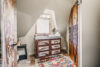 Brightly lit bathroom with vintage vanity area and a sloped ceiling.