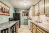 Homely full-size kitchen in the basement with added space to do laundry.