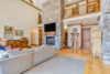 Open living room area with a gorgeous floor-to-ceiling stone fireplace.