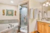 Elegant bathroom with a large corner tub, glass door shower, and vanity area.