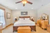 Warmly decorated bedroom with an added vanity and chest at the foot of the bed.