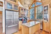 Lovely kitchen with a full-size refrigerator and light wood cabinets.