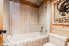 White-tiled bathroom complete with a rainfall shower head.