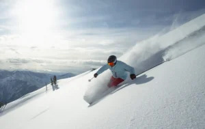 A skier makes their way down the slope through freshly fallen snow.