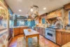 Charming kitchen with a large refrigerator, and a pots and pans hanging area.