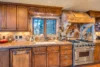This family-friendly kitchen has a gas range stove, farm-house style sink, and granite countertops.