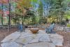 Beautiful outdoor firepit nestled among the trees with added seating room.