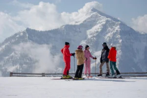 Five skiers enjoy the breathtaking views and good company at the top of the mountain.