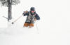 Man skis down the mountain covered in fresh powder.