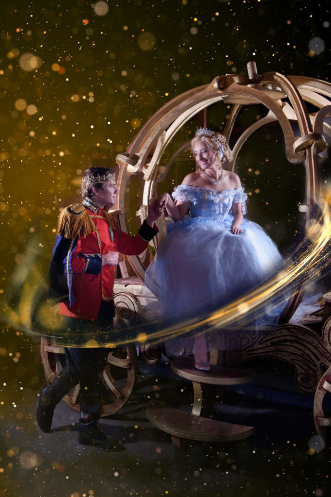 Prince Charming helps Cinderella out of her golden carriage. 