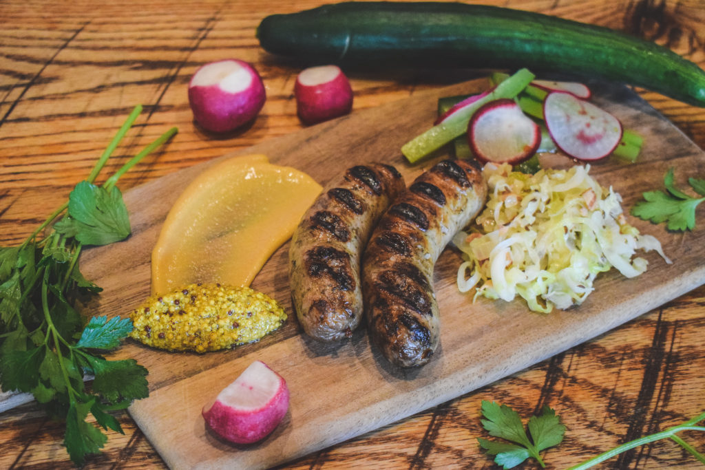 German wurst displayed beautifully with a variety of vegetables and sauces. 