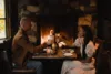 A couple enjoys a delicious meal cozied up by the fireplace.