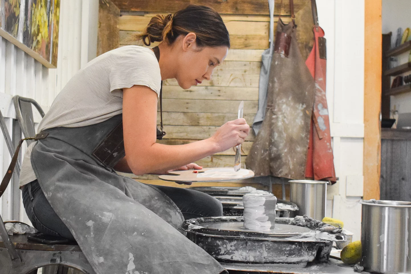 Woman in a Sundance pottery class painting her piece.