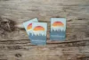 Two sundance mountain resort lift tickets on a rustic wooden background. the tickets feature a scenic design with a sunset and mountain silhouette.