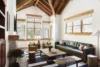 Warm and inviting living room with a modern couch and chairs, and large windows providing natural light.