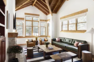 Warm and inviting living room with a modern couch and chairs, and large windows providing natural light.