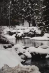 Snapshot of a river in the winter with the banks covered in snow.