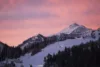 Snow covered mountain backed by a pink sky in the early hours of the day.