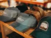 A collection of baseball caps on a wooden shelf, with one prominently displaying the 