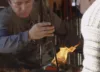 Two professional glass blowers work together to create a masterpiece.