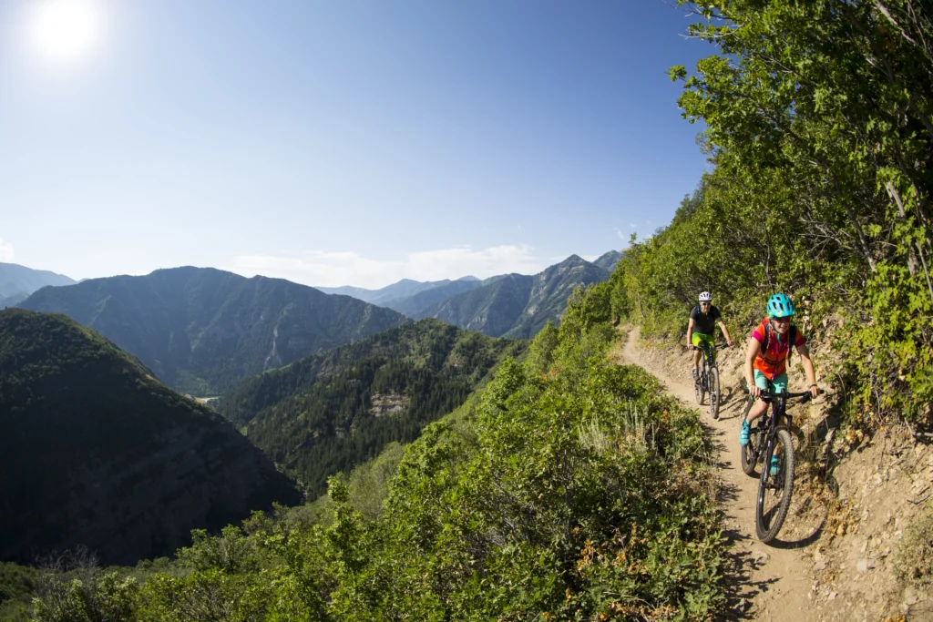 Beautiful mountain scenery with two bikers racing down the mountain. 