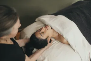 A woman lies on a comfortable bed during her relaxing massage.