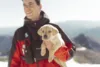 Avalanche patrol dog being held by it's trainer.