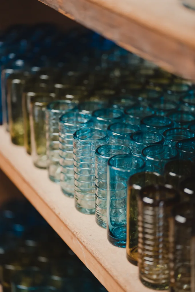 Colorful shelf of cups made from recycled glass. 