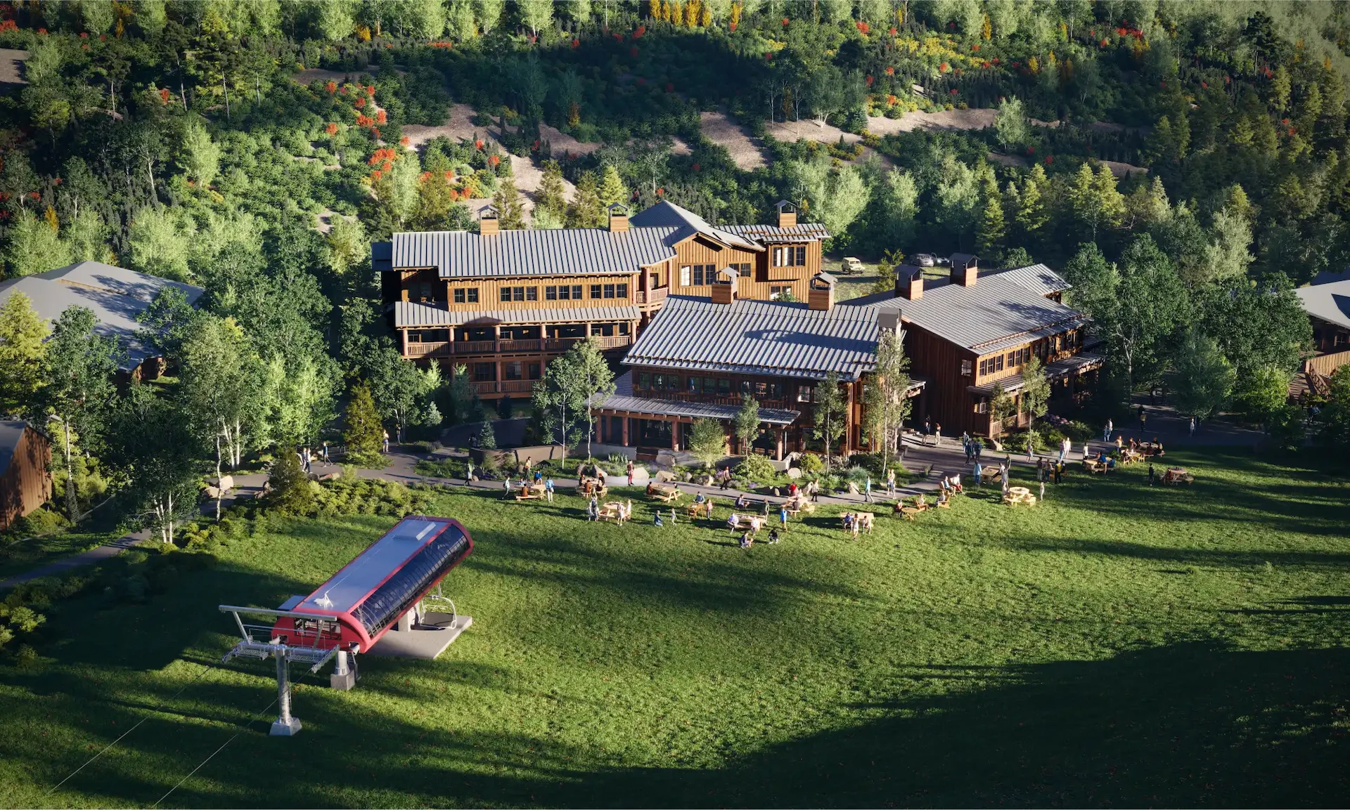 A scenic aerial view of a rustic lodge nestled within a lush, densely forested area. The lodge has several buildings with wooden exteriors and metal roofs. In front, there is a grassy lawn with scattered seating, and a red gondola station is visible on the left.