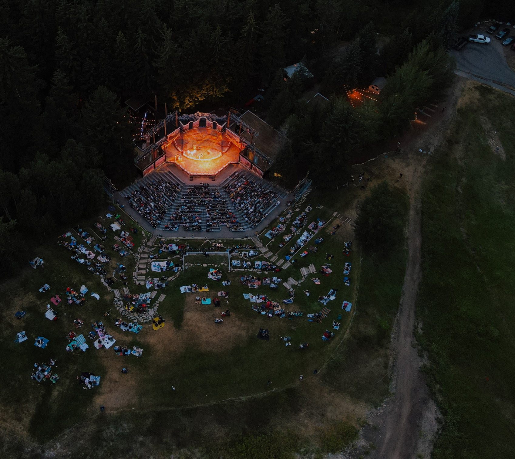 bird's eye view of sundance's bluebird stage in the evening with a lit up stage and the crowd surrounding it