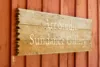 A weathered wooden sign with white text reading 